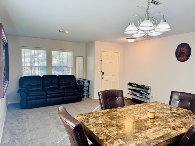 carpeted dining room with a chandelier