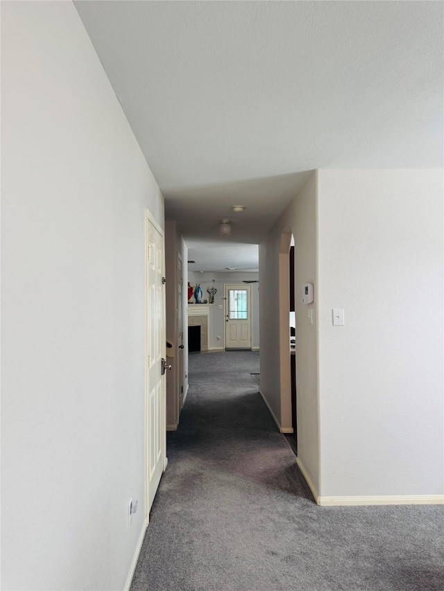 hallway featuring dark colored carpet