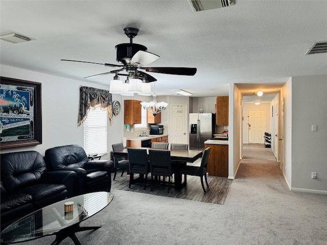 dining area featuring a textured ceiling, ceiling fan, and carpet