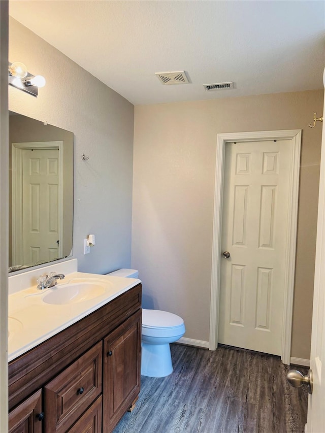 bathroom with vanity, hardwood / wood-style floors, and toilet