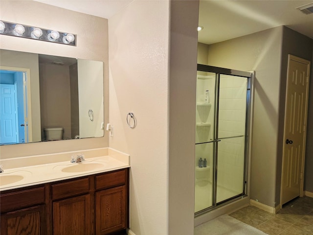 bathroom featuring walk in shower, tile patterned floors, vanity, and toilet