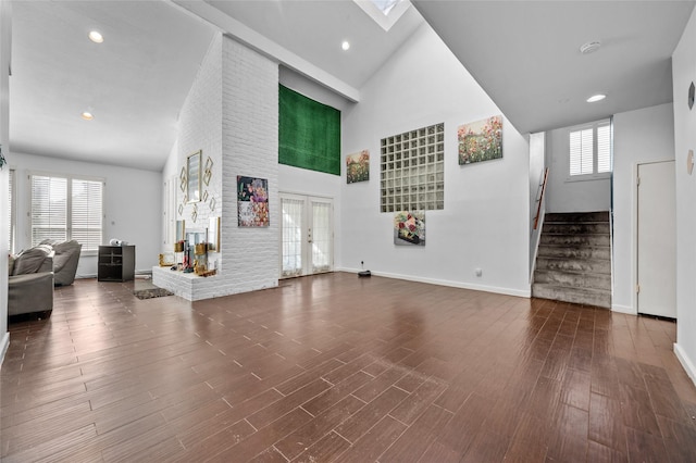 14323 Briarhills Pkwy, Houston, TX 77077 - unfurnished living room featuring high vaulted ceiling, stairway, recessed lighting, wood finished floors, and french doors