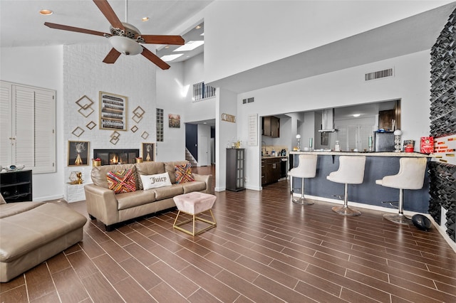 14323 Briarhills Pkwy, Houston, TX 77077 - living area featuring a towering ceiling, a ceiling fan, and a fireplace