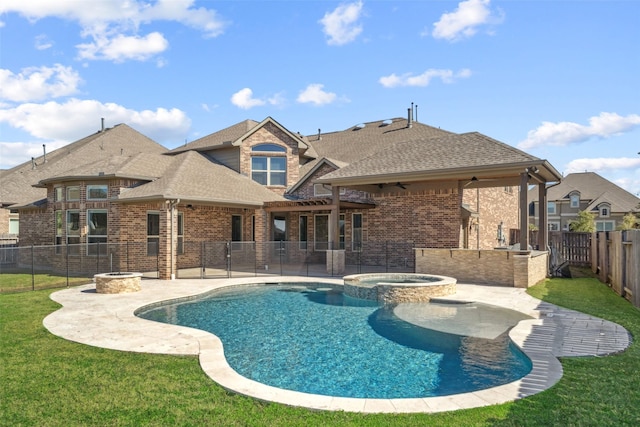 view of swimming pool with an in ground hot tub, a yard, ceiling fan, an outdoor fire pit, and a patio area