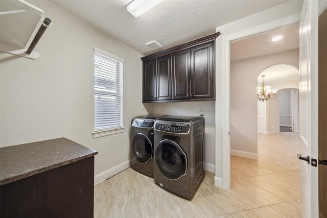 19031 Kimber Creek Ln, Cypress, TX 77429 - laundry room featuring cabinet space, arched walkways, washing machine and dryer, a chandelier, and baseboards