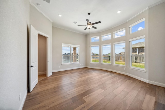 spare room featuring wood-type flooring, ceiling fan, and crown molding