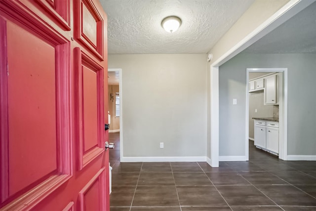 tiled foyer entrance featuring a textured ceiling