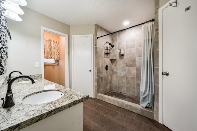 bathroom with vanity, curtained shower, tile patterned flooring, and a textured ceiling