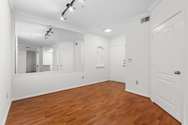 spare room with hardwood / wood-style floors, crown molding, and track lighting