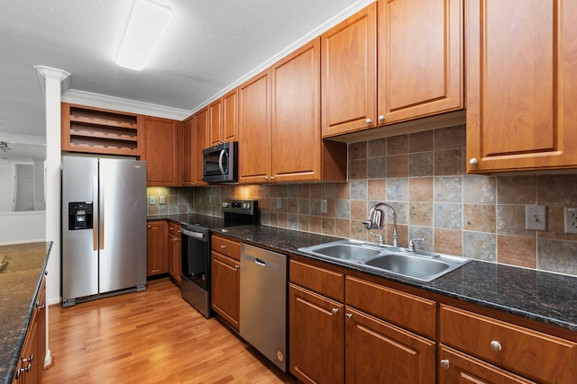 kitchen featuring sink, crown molding, appliances with stainless steel finishes, tasteful backsplash, and light wood-type flooring