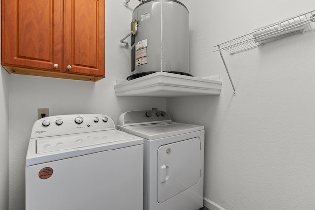 laundry area with cabinets, independent washer and dryer, and water heater