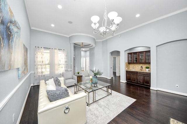 living room featuring crown molding, an inviting chandelier, and dark hardwood / wood-style flooring