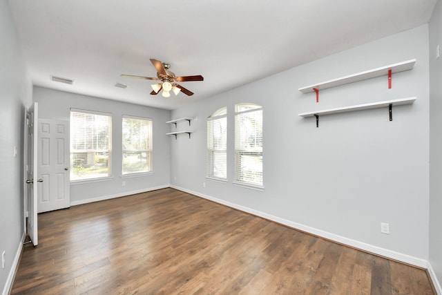 empty room featuring dark wood-type flooring and ceiling fan