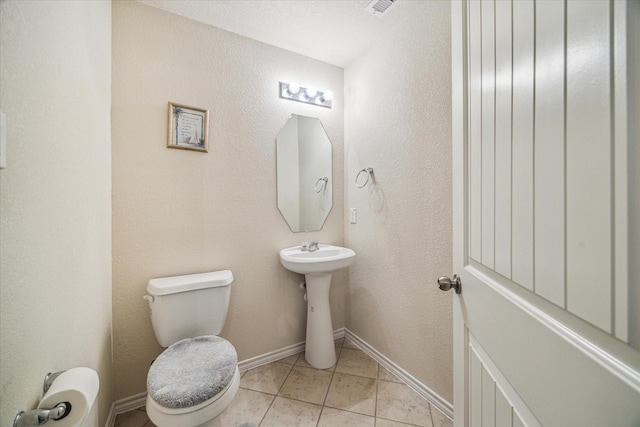 bathroom with toilet and tile patterned flooring