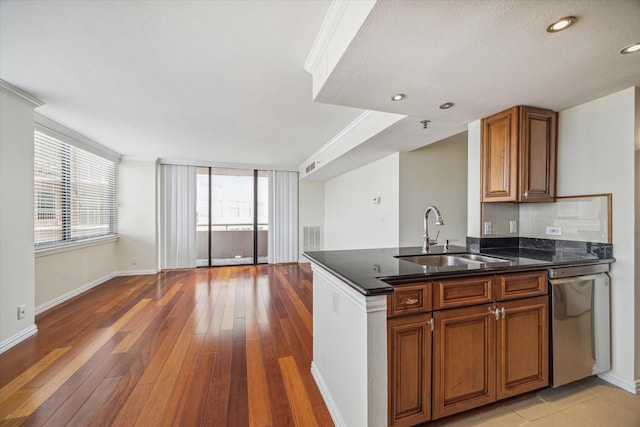 kitchen with a healthy amount of sunlight, sink, backsplash, and dishwasher