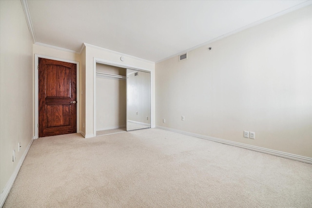 unfurnished bedroom with crown molding, light colored carpet, and a closet