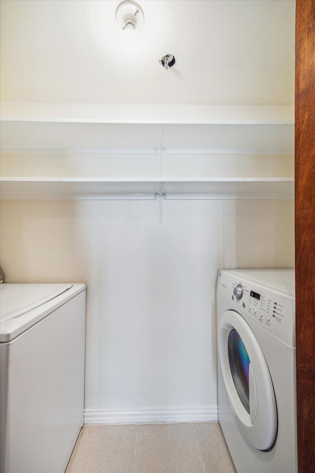 washroom featuring washing machine and dryer and light tile patterned floors