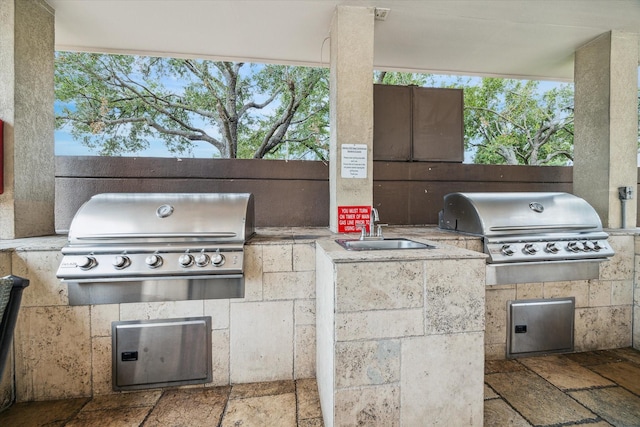 view of patio / terrace featuring area for grilling, sink, and a grill