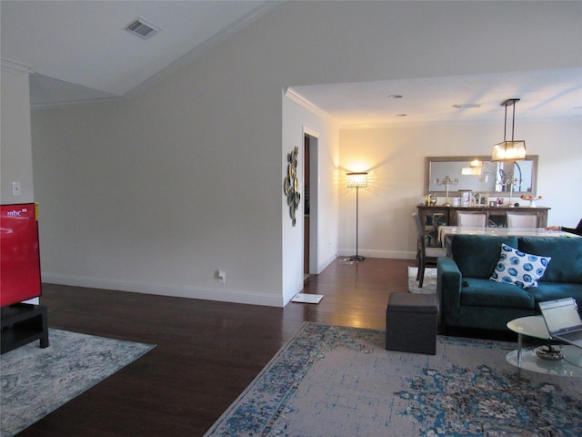 living room featuring lofted ceiling, ornamental molding, and dark hardwood / wood-style floors