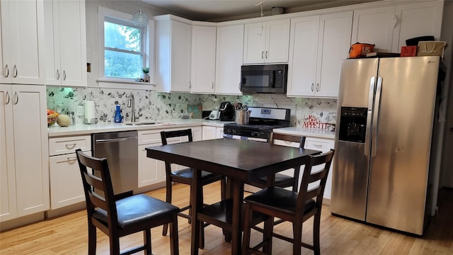 kitchen featuring white cabinetry, sink, light wood-type flooring, and appliances with stainless steel finishes