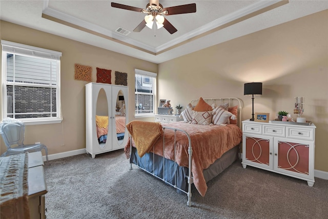 bedroom featuring crown molding, a tray ceiling, and dark colored carpet