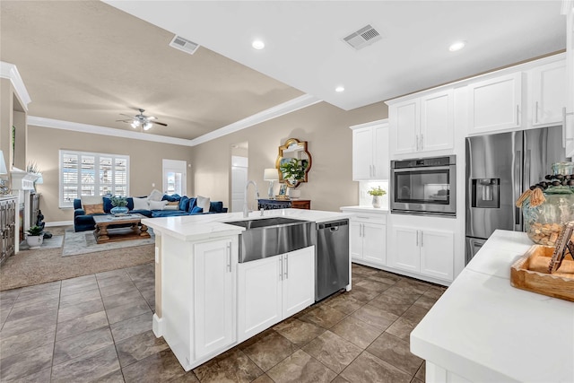 kitchen with sink, appliances with stainless steel finishes, an island with sink, ceiling fan, and white cabinets