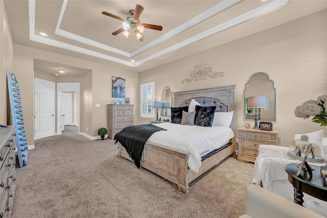 carpeted bedroom featuring a tray ceiling, ornamental molding, and ceiling fan