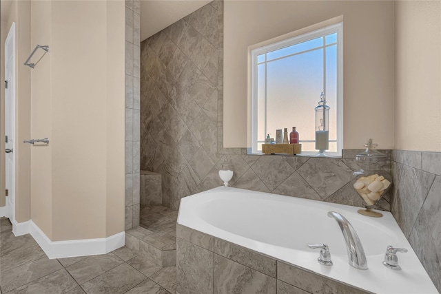 bathroom featuring a healthy amount of sunlight and tiled bath