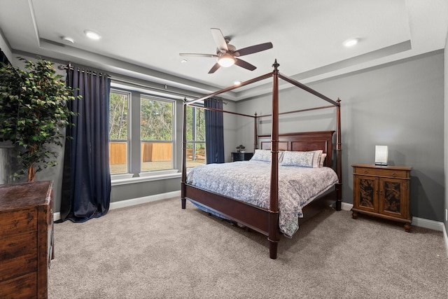 bedroom with carpet floors, a raised ceiling, and ceiling fan