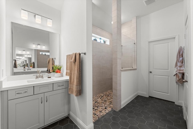 bathroom featuring vanity, tile patterned flooring, and a tile shower