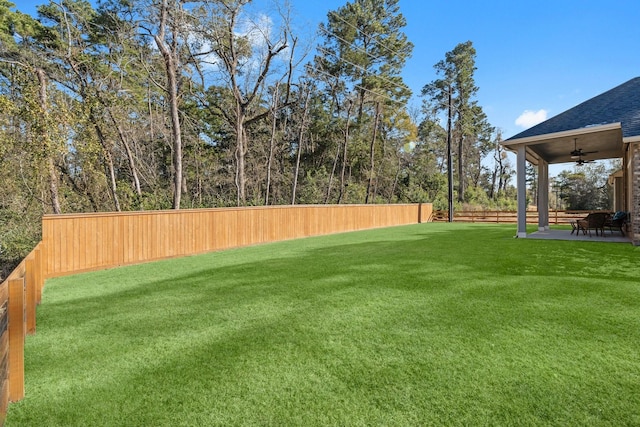 view of yard with ceiling fan and a patio area