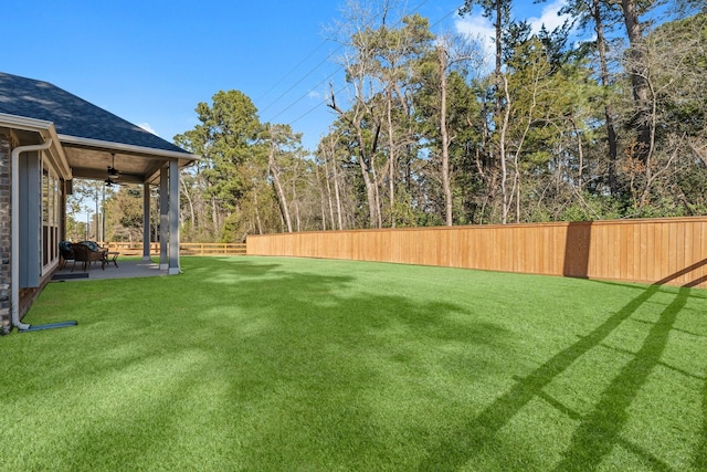 view of yard with ceiling fan and a patio area