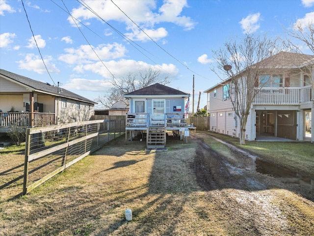 exterior space with a garage, a wooden deck, and a front lawn