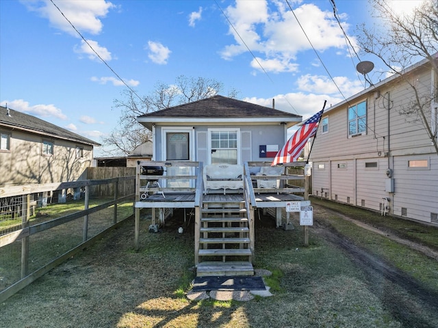 rear view of property featuring fence, stairs, a shingled roof, and a wooden deck