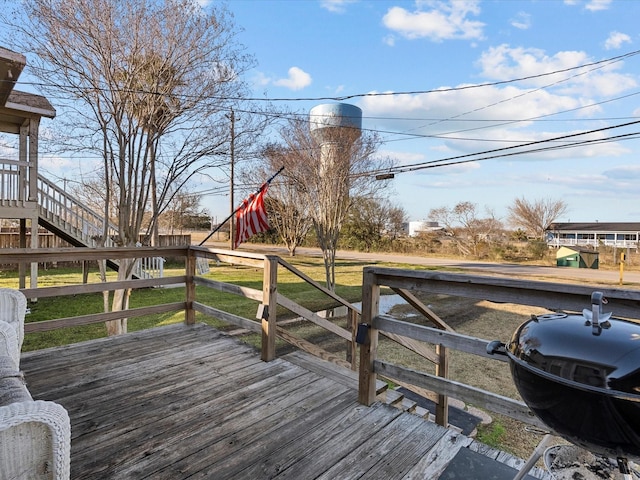 deck with a grill, stairs, and a lawn