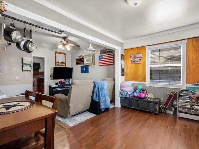 living room with ceiling fan, wood-type flooring, a wall unit AC, and wood walls