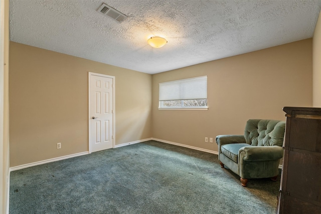 unfurnished room with a textured ceiling and dark colored carpet