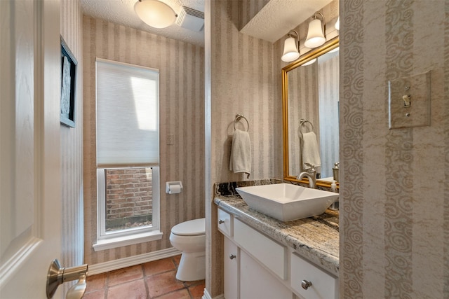 bathroom featuring vanity, a textured ceiling, and toilet