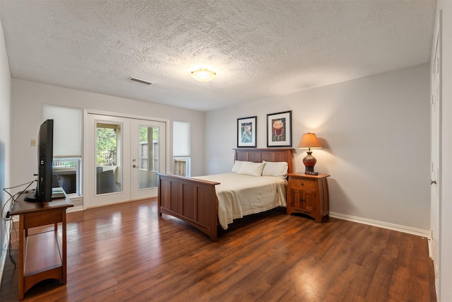 bedroom with access to exterior, dark hardwood / wood-style floors, french doors, and a textured ceiling