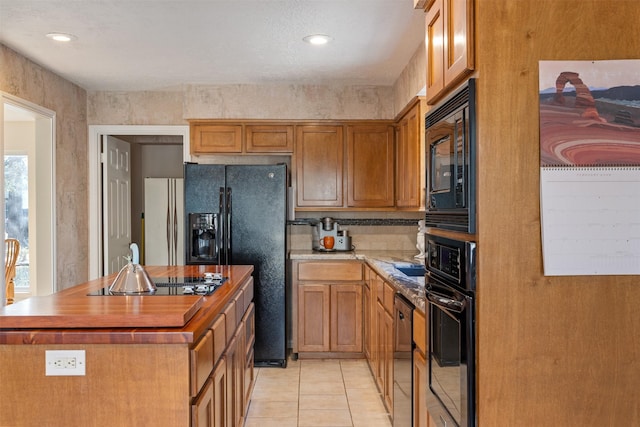 kitchen with tasteful backsplash, light tile patterned floors, and black appliances