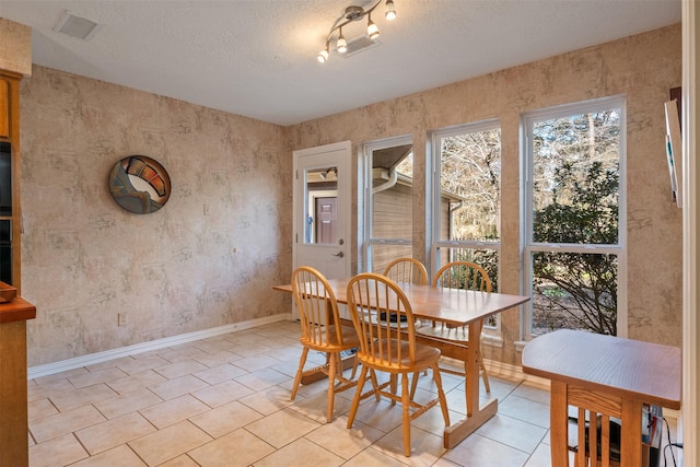 tiled dining room with a textured ceiling