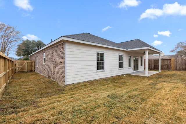 rear view of property featuring a yard, ceiling fan, and a patio area