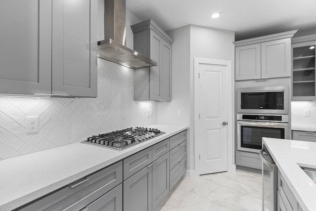 kitchen featuring extractor fan, light stone counters, appliances with stainless steel finishes, gray cabinets, and decorative backsplash