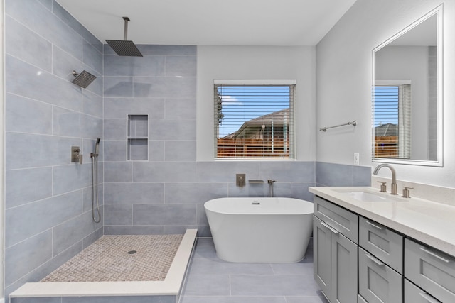 bathroom with tile patterned flooring, plus walk in shower, tile walls, and vanity