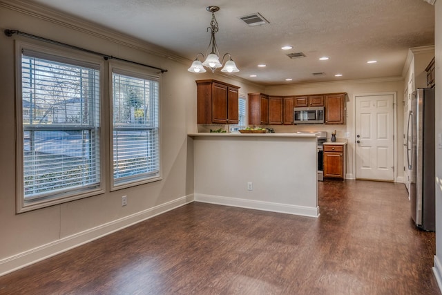 kitchen featuring crown molding, decorative light fixtures, kitchen peninsula, and appliances with stainless steel finishes