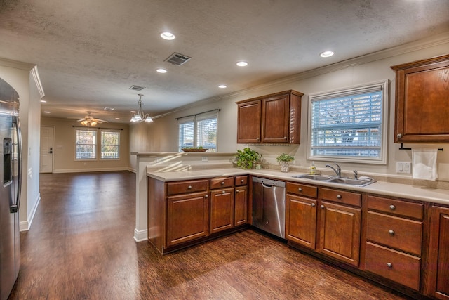 kitchen featuring appliances with stainless steel finishes, decorative light fixtures, sink, and a textured ceiling