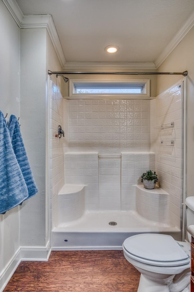 bathroom featuring wood-type flooring, ornamental molding, a wealth of natural light, and toilet