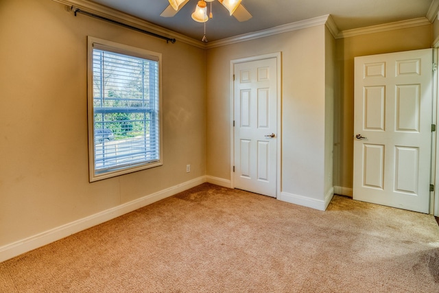 unfurnished bedroom featuring light carpet, crown molding, and ceiling fan