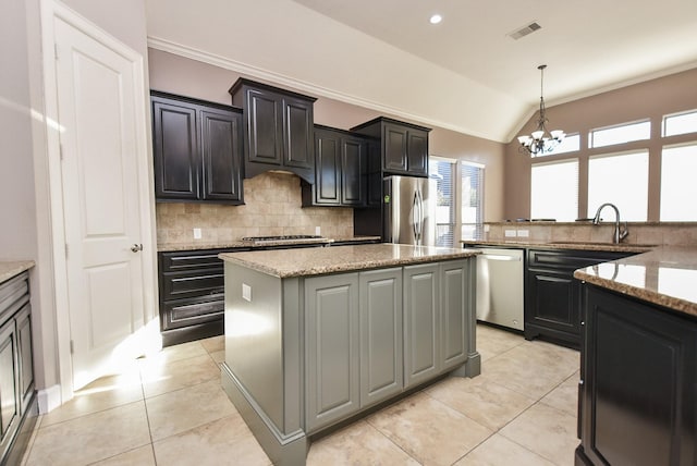 kitchen featuring visible vents, a kitchen island, appliances with stainless steel finishes, an inviting chandelier, and a sink