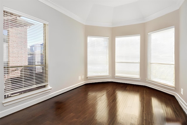 empty room featuring ornamental molding, vaulted ceiling, and wood-type flooring